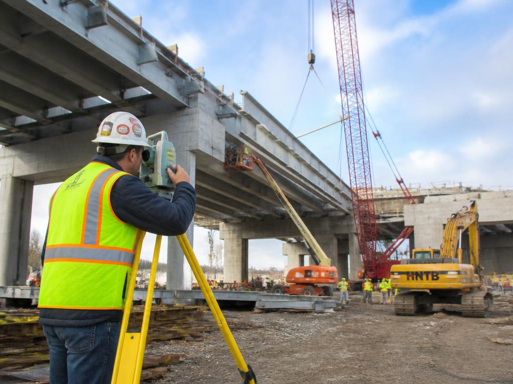 Engineer surveying a highway bridge construction project